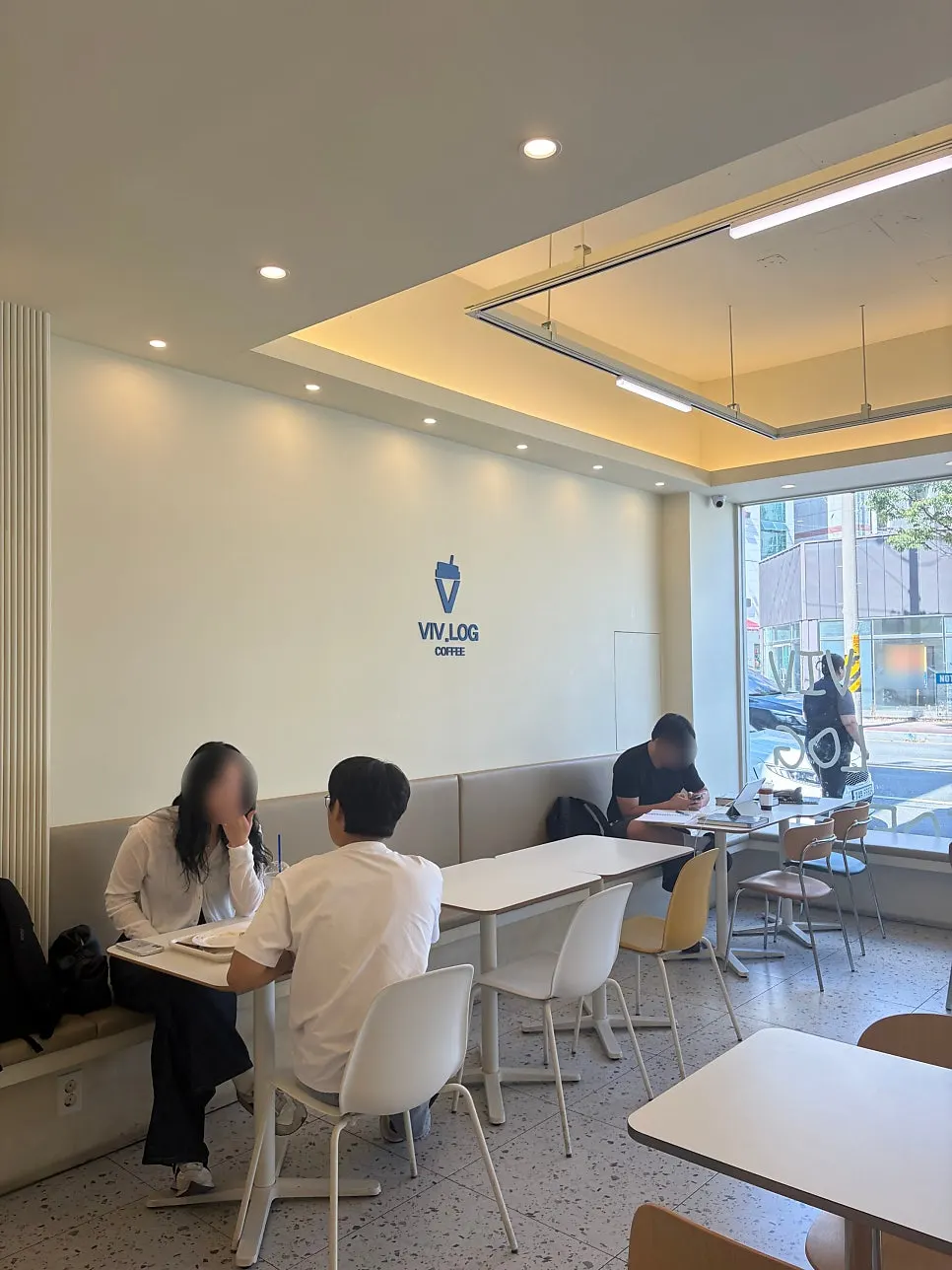 Wall-side seating in the white-toned café interior