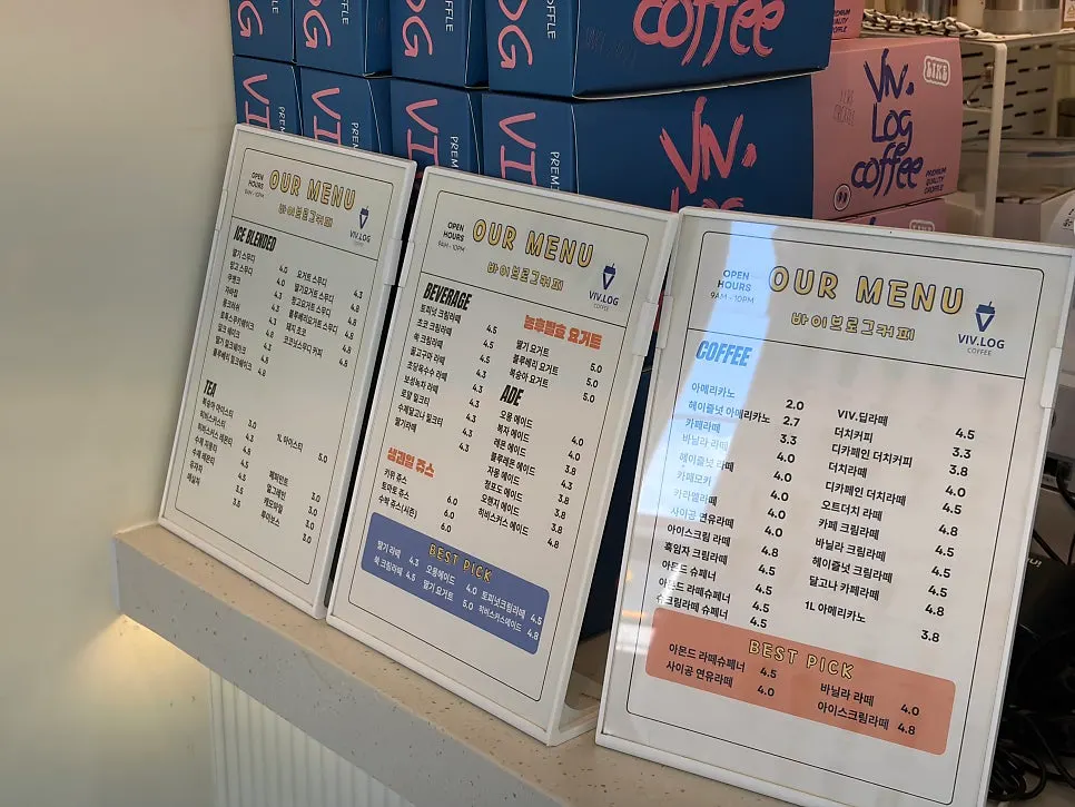 Menu board listing coffee, lattes, and ades