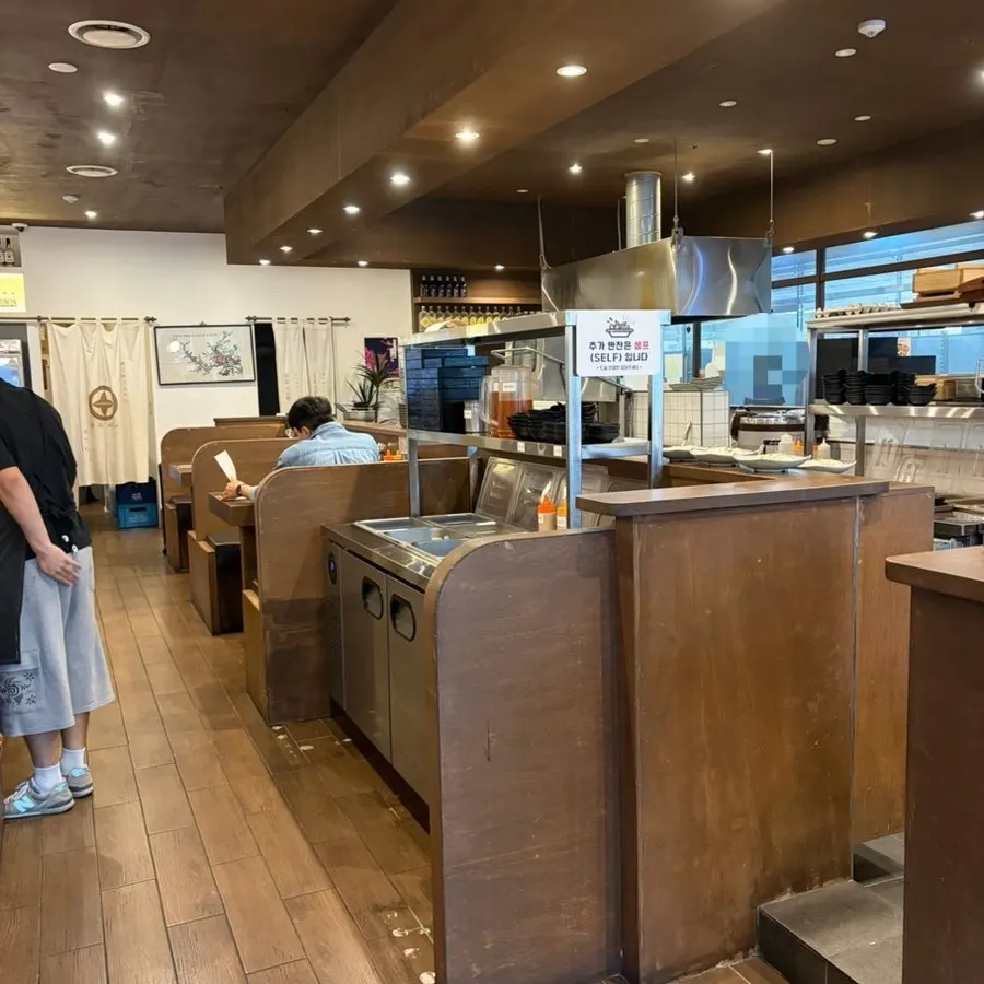 Wood-toned interior seating at Yuyu Shabu Naju Innovation City branch