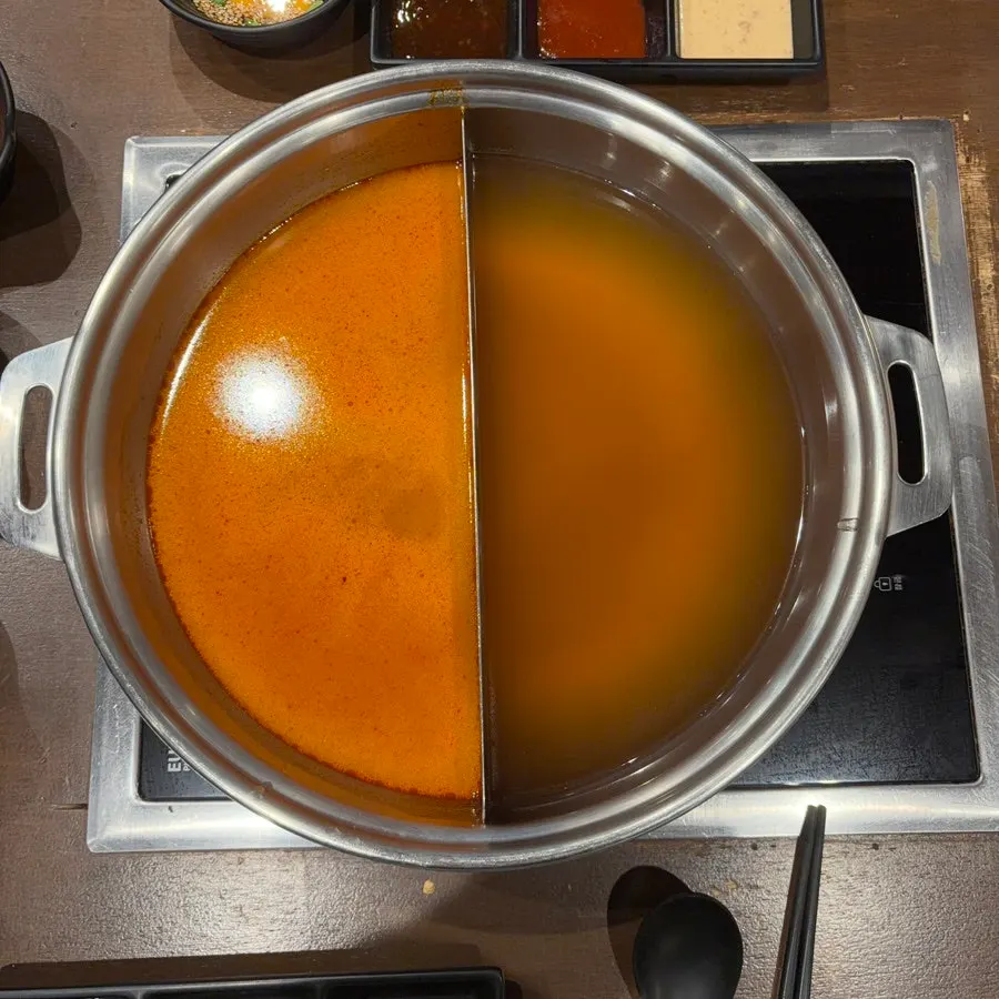 Table with a half basic, half mala broth pot
