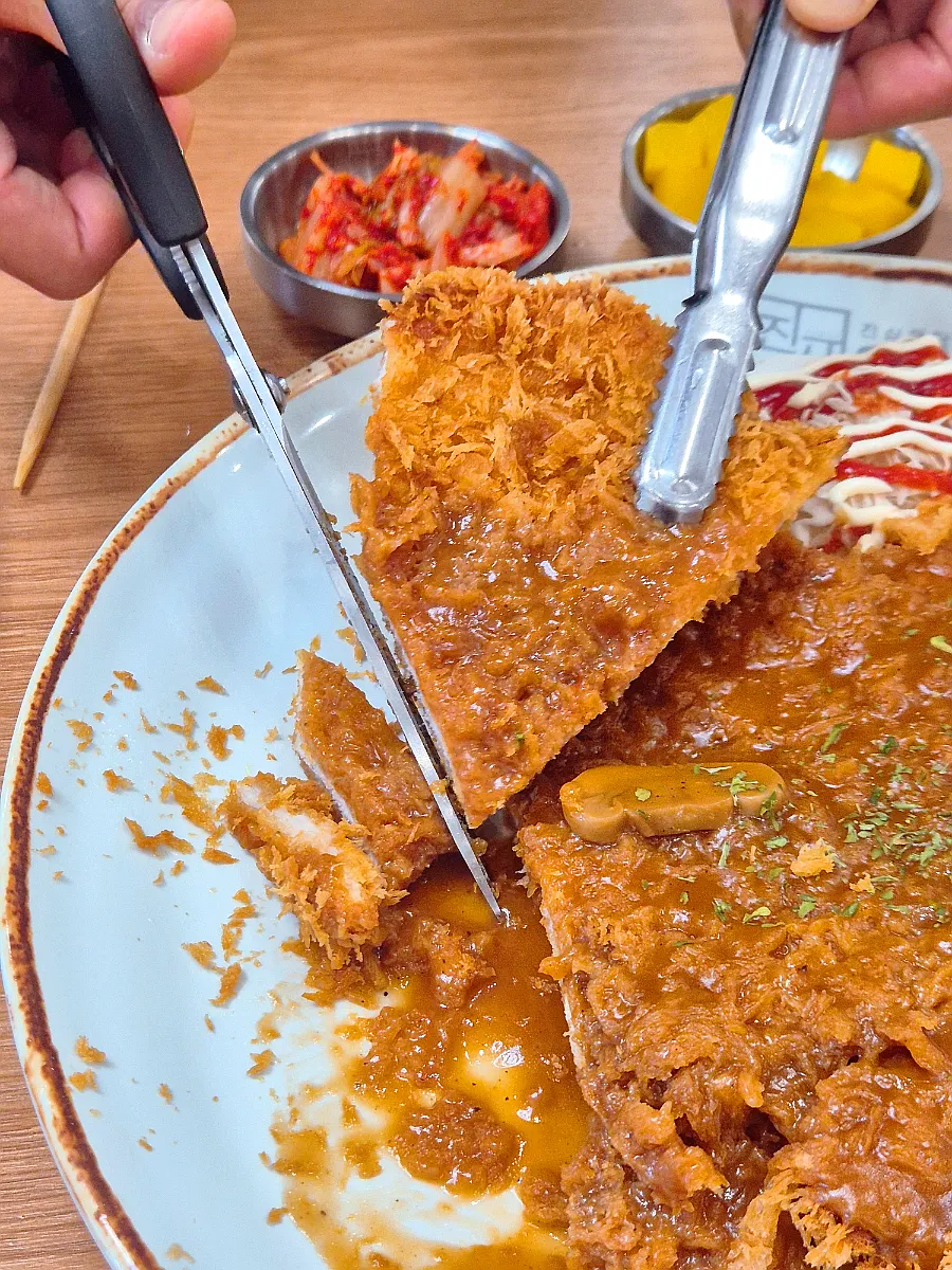 Giant pork cutlet cut apart with scissors