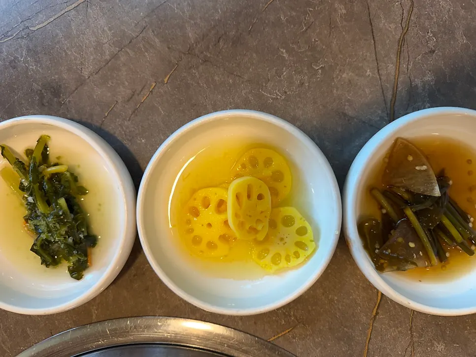 Spread of side dishes including soy-marinated crab and lettuce wraps