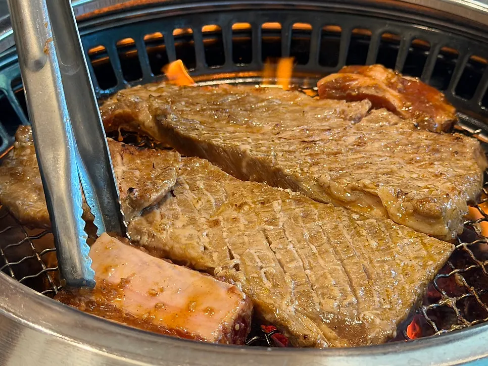 Thick, marinated pork ribs being grilled