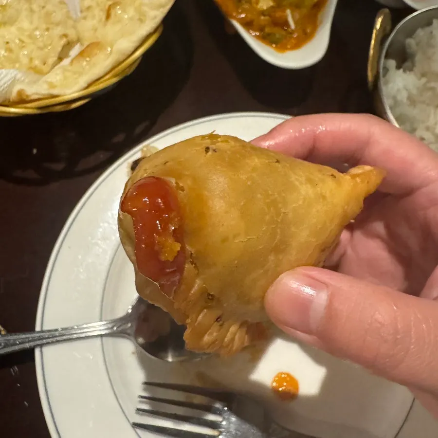 반으로 갈라 감자와 채소가 보이는 사모사