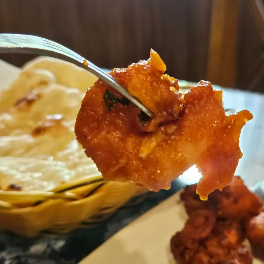 A piece of shrimp chili being picked up