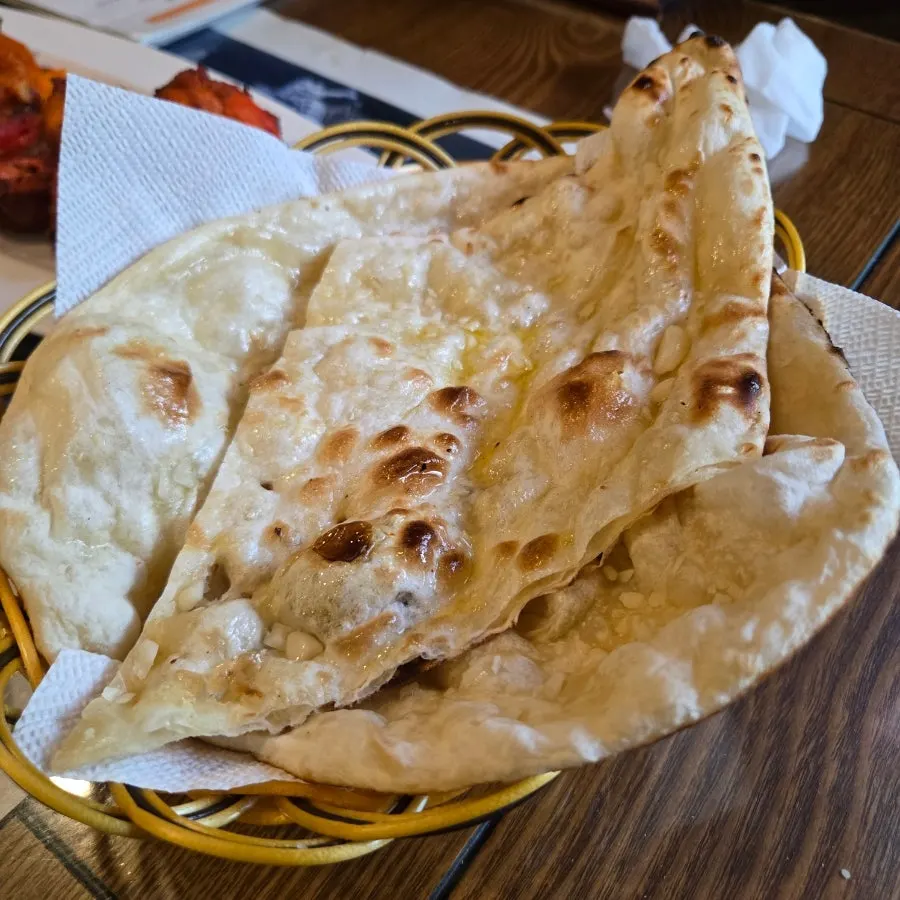 Garlic naan served alongside the curry