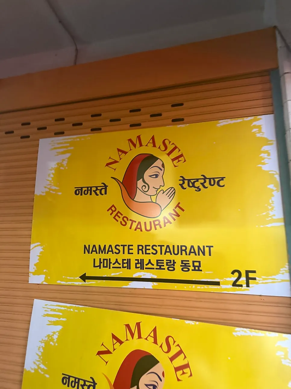 Stairs and sign leading up to Namaste Dongmyo Branch