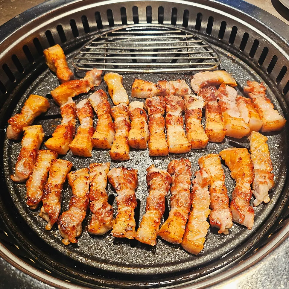 Pork belly being grilled skin-side first