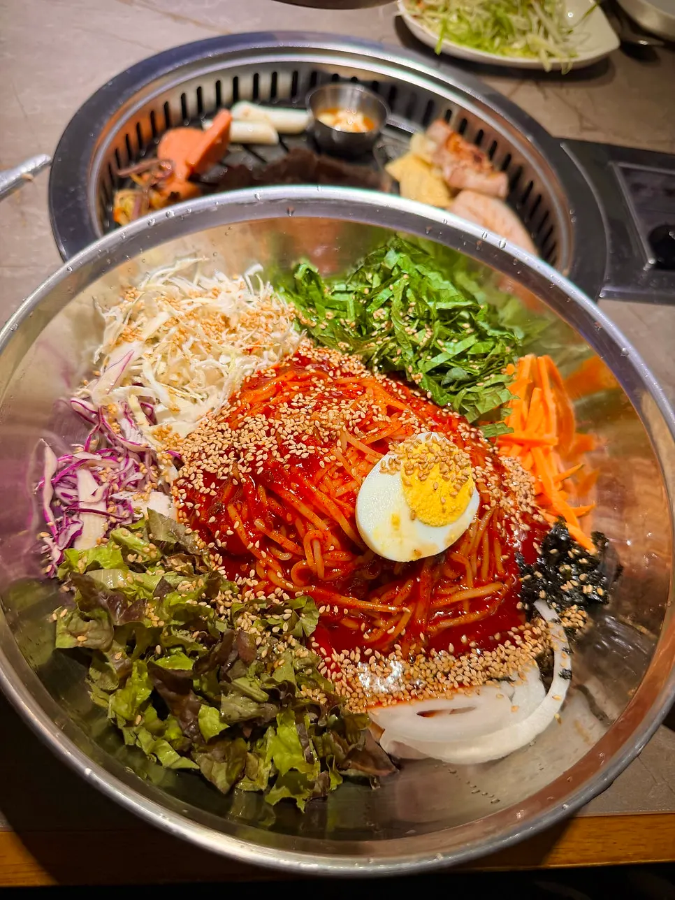 Table setting with giant spicy vegetable jjolmyeon and pork belly set