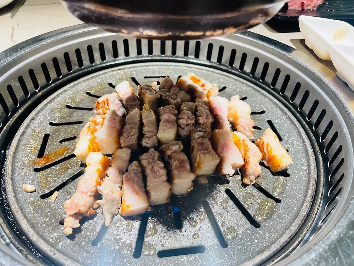 불판에서 노릇하게 구워지는 삼겹살