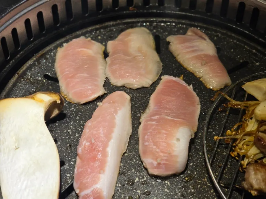 Pork jowl grilling on the grill