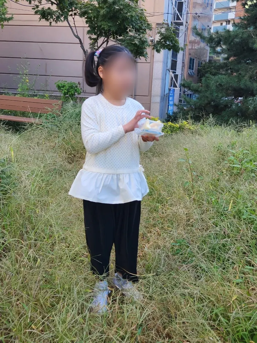 A 7-year-old girl trying on the frilly top
