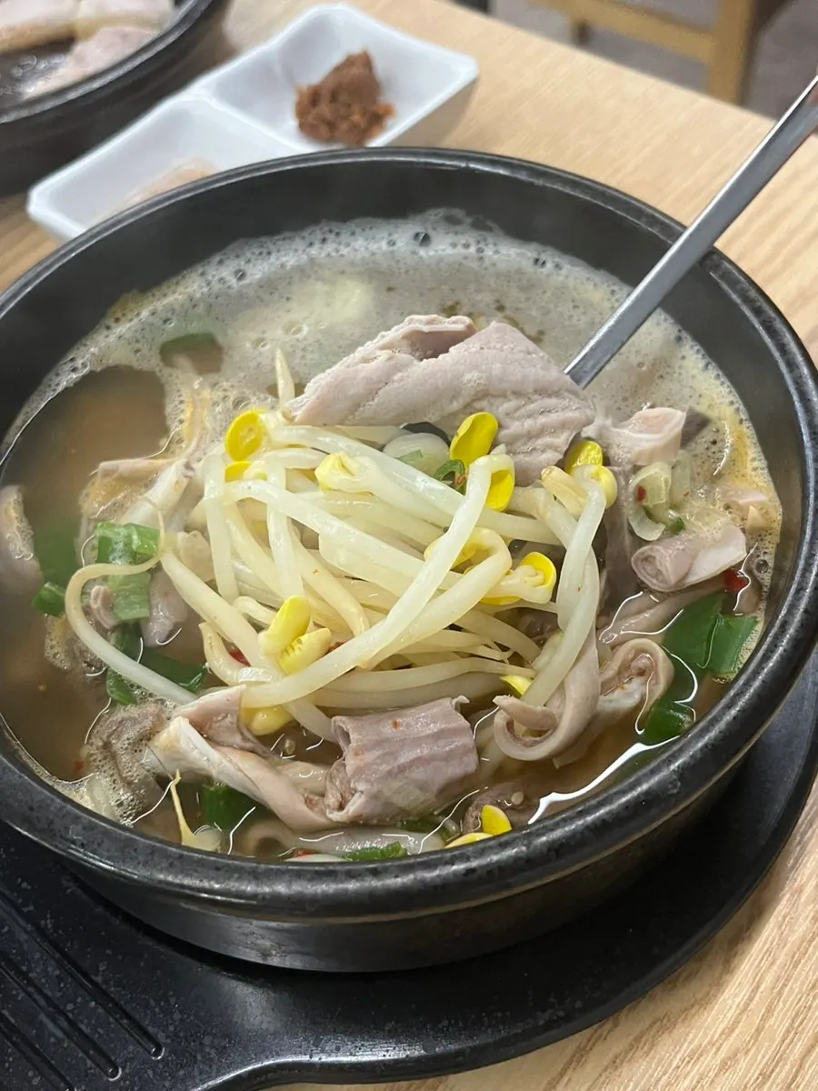 A piece of gukbap innards dipped in the sauce