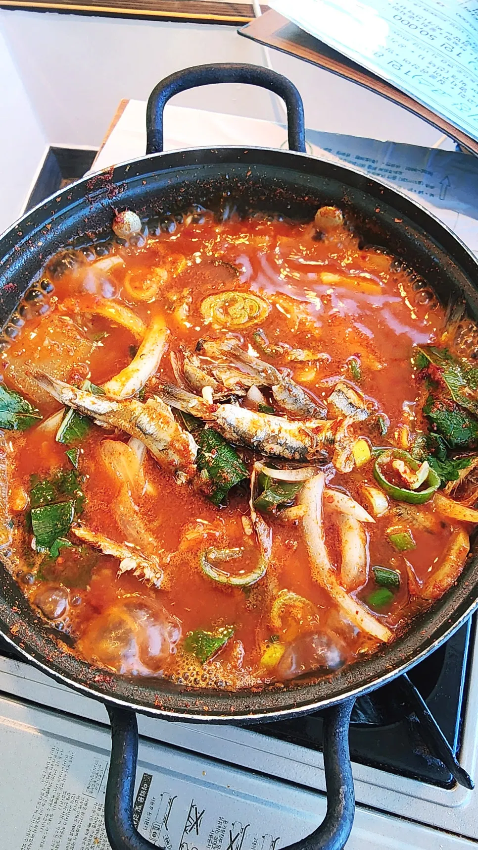 Grilled anchovy served on a cast-iron pan