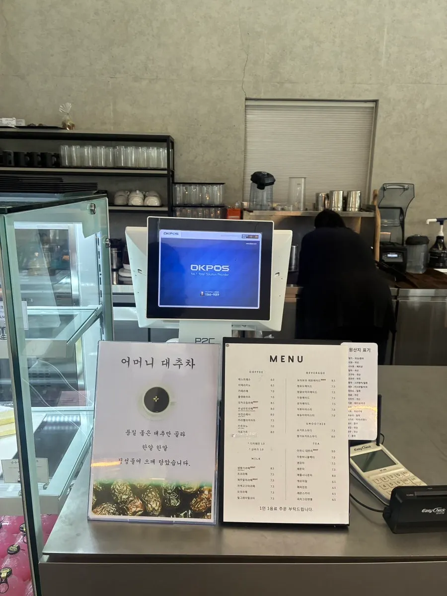 Long bakery display case set against the floor-to-ceiling windows
