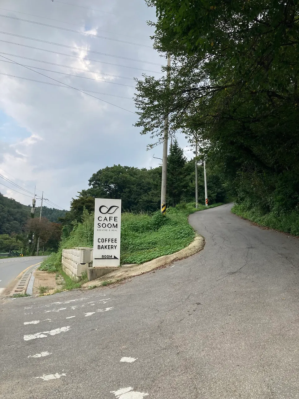 오전리 농산물 직거래장터 입구의 카페 숨 진입로 간판