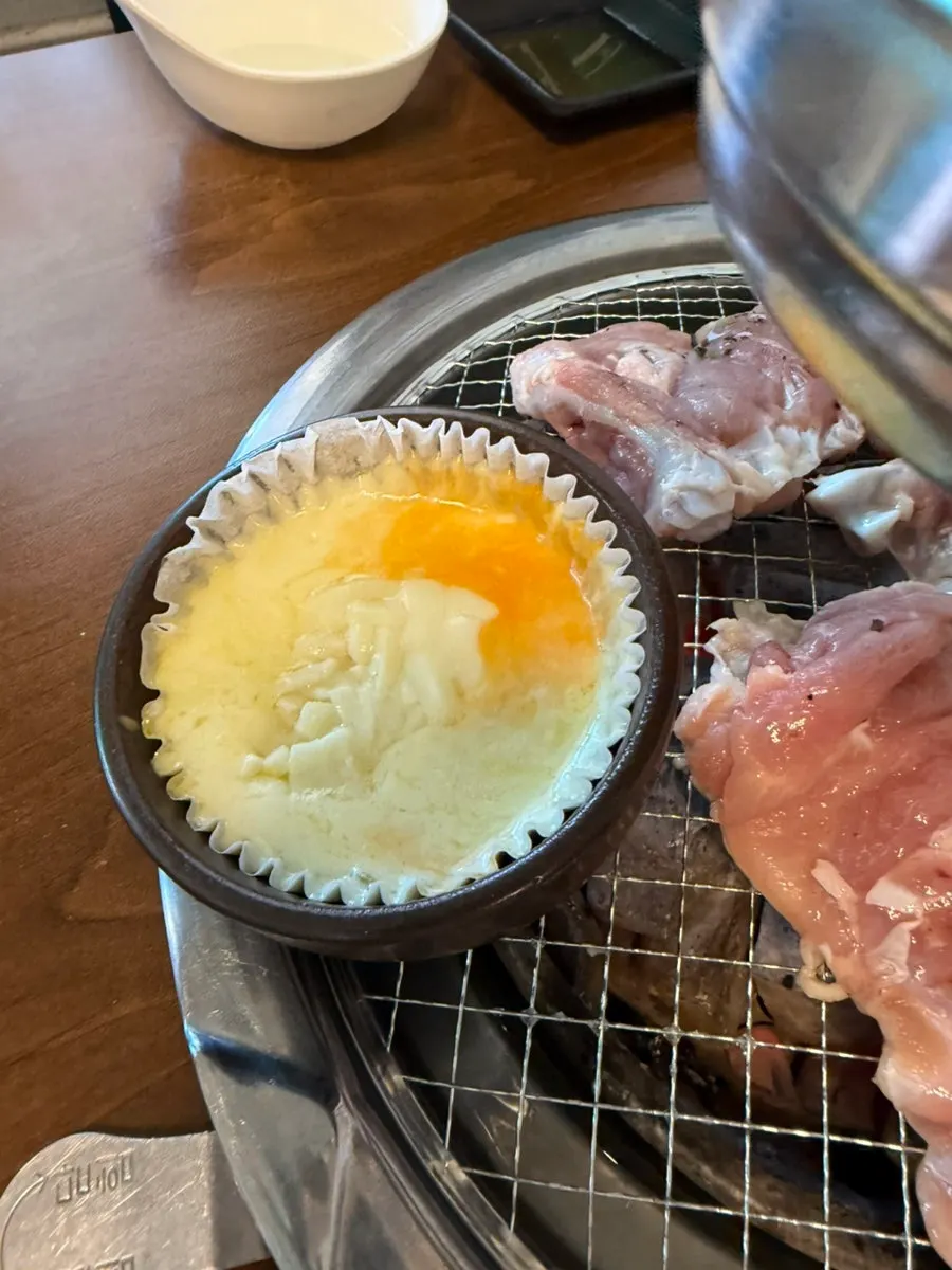 Cheese fondue melting beside the charcoal grill
