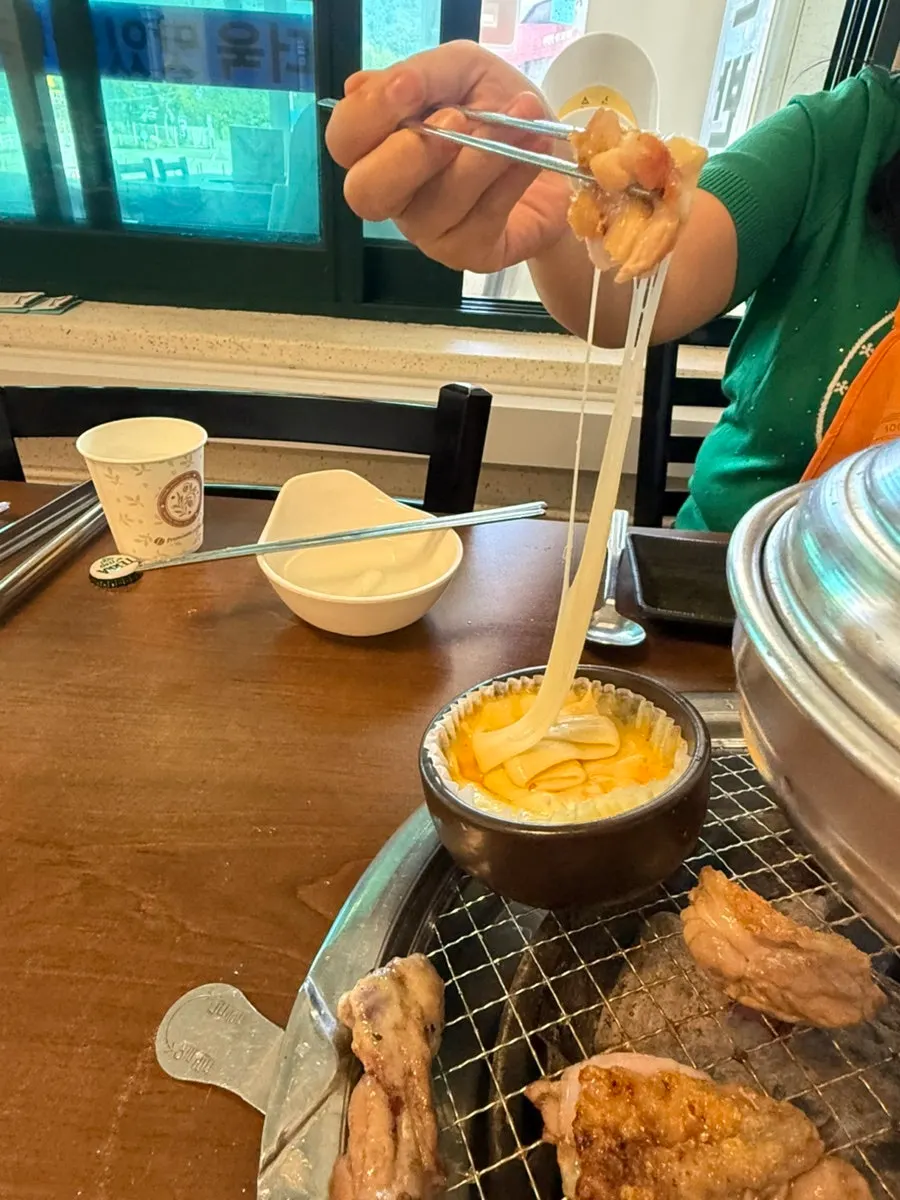 Dakgalbi dipped into cheese fondue and lifted up
