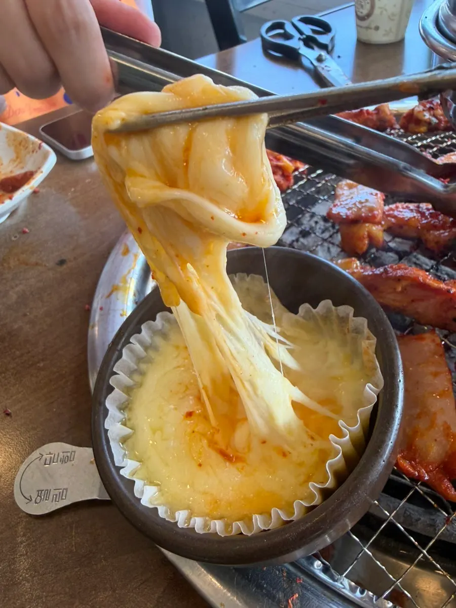 Seasoned dakgalbi cooking over charcoal