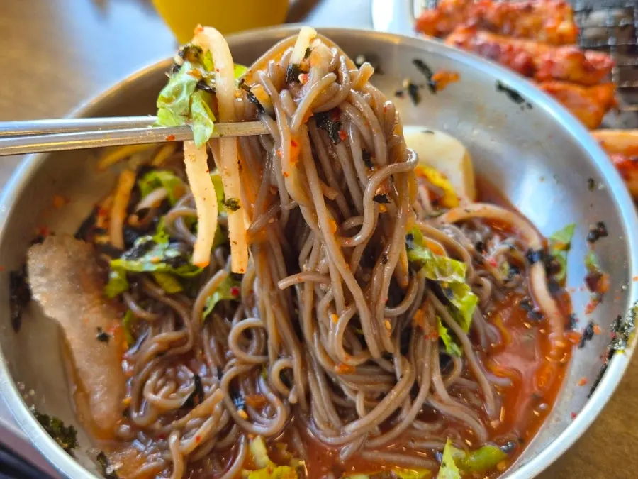 Bowl of buckwheat mak guksu topped with slushy ice