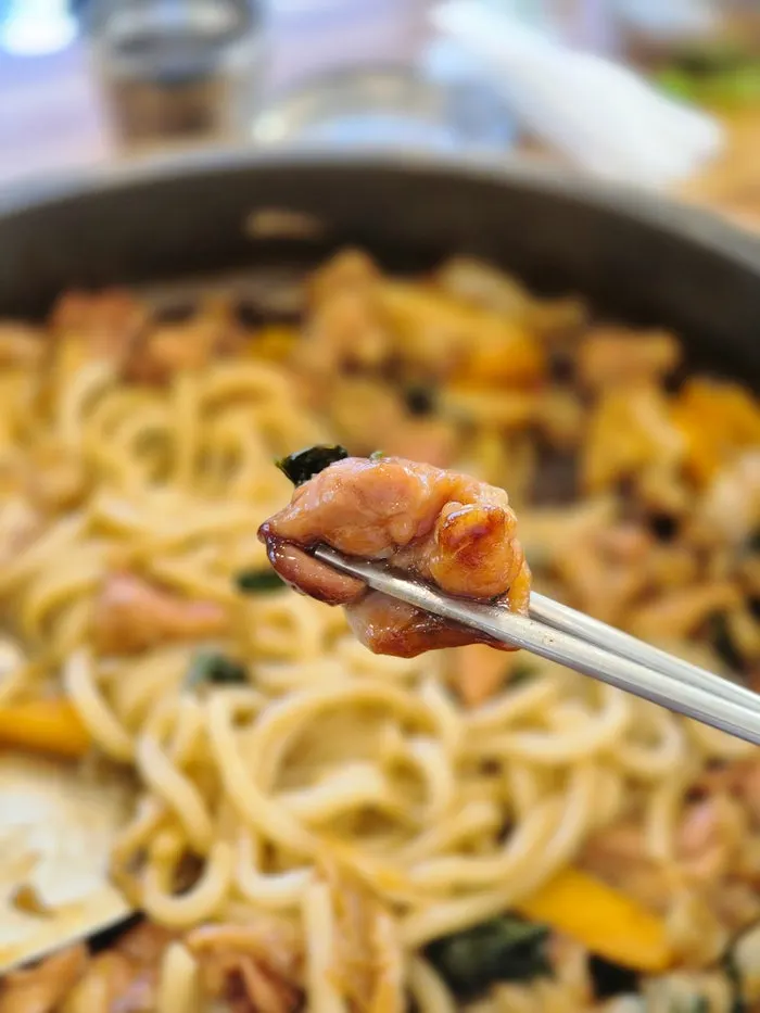Hot-plate dakgalbi being stir-fried with glass noodles added
