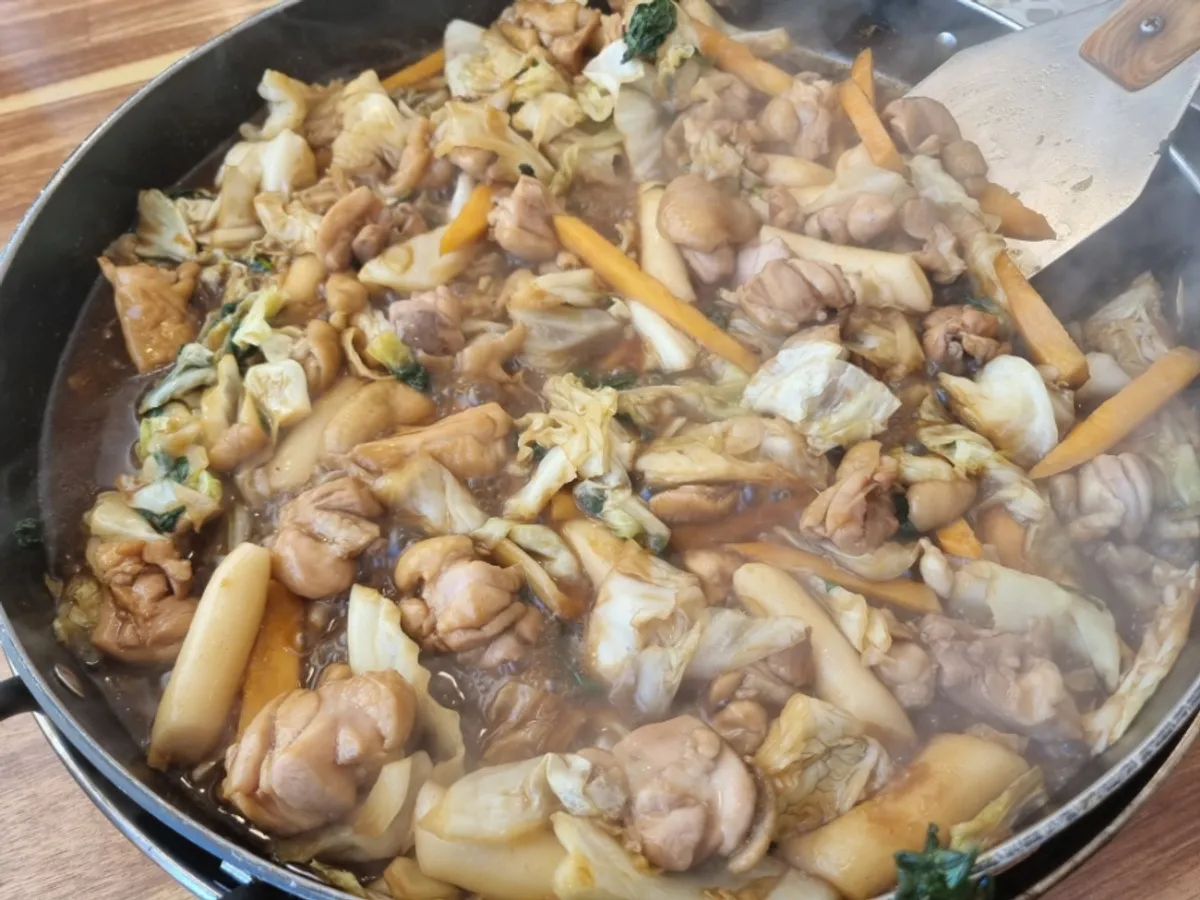 Fully cooked soy sauce dakgalbi with cabbage and perilla leaves
