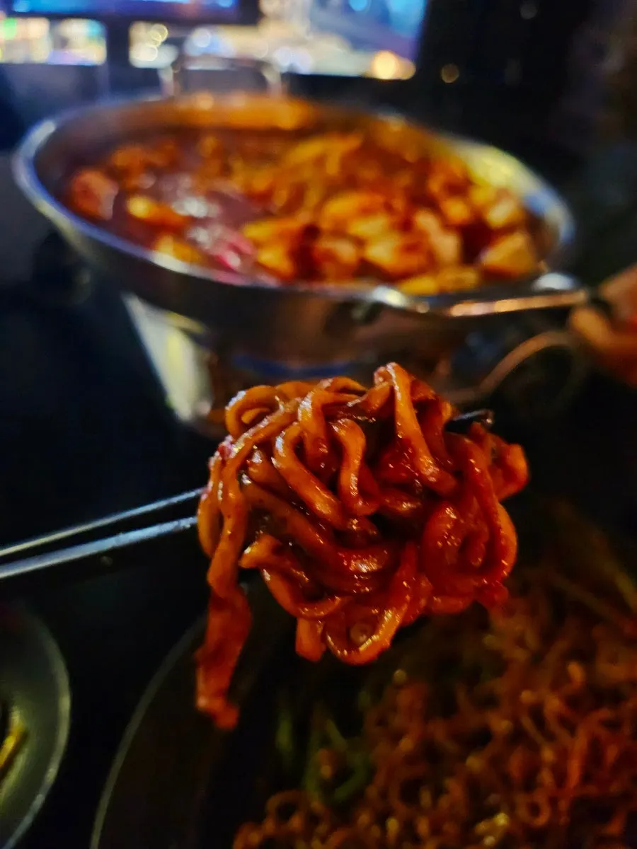 Jjapagetti topped with green onion kimchi