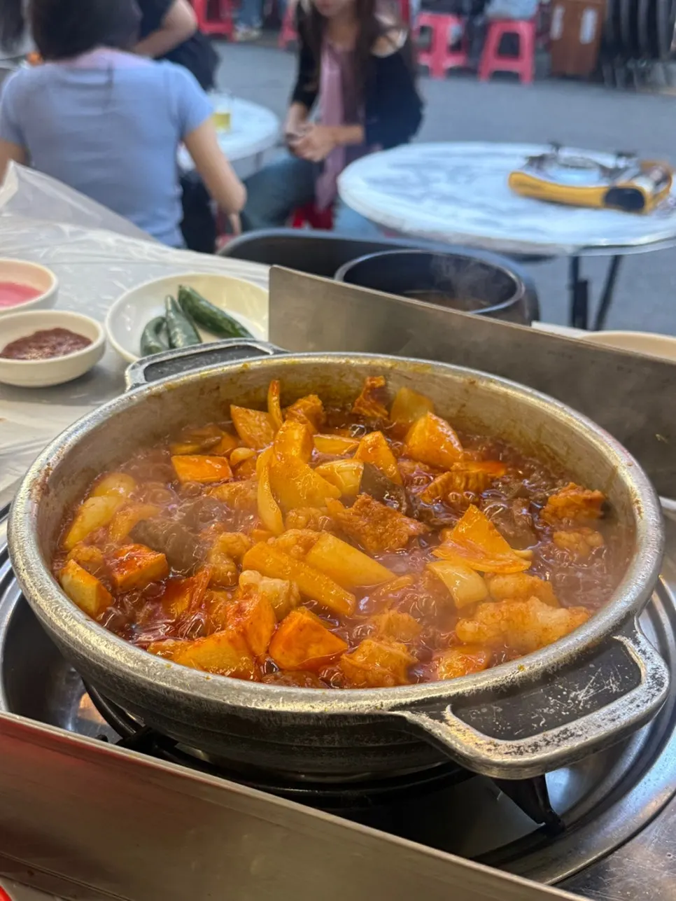 Staff member grilling the stone-pan seasoned yang gopchang