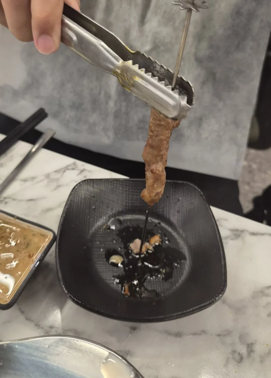 Grilled skewers slid off with tongs