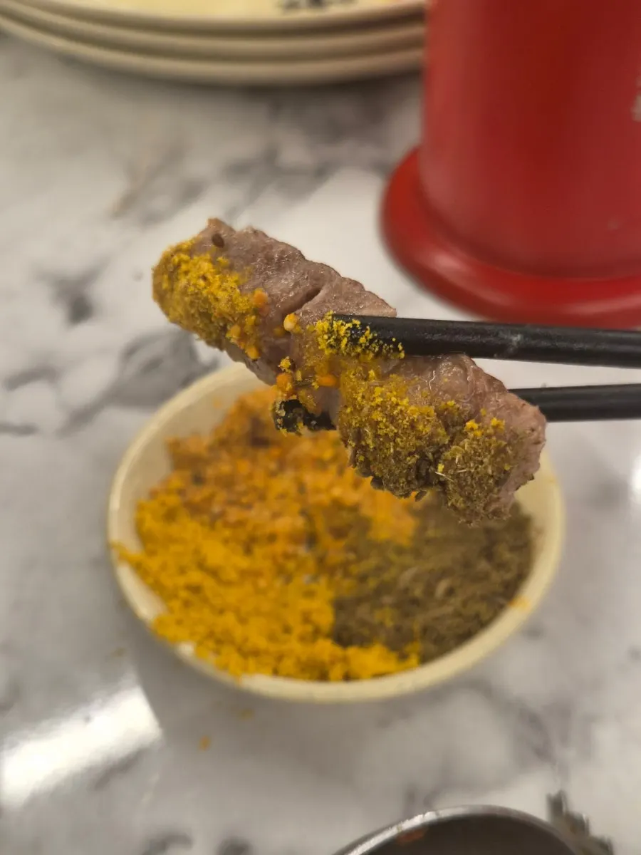 Skewer being dipped in cumin and zira seed