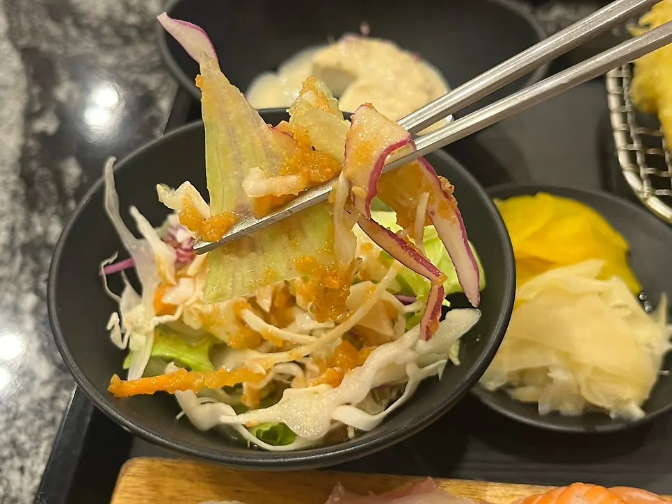 Salad served alongside sushi