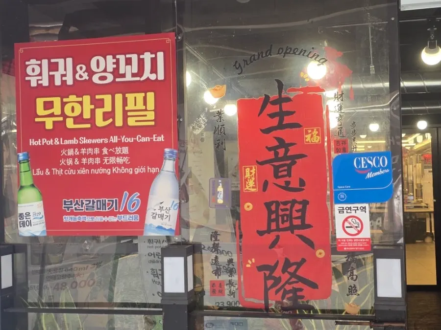 Restaurant entrance with a sign reading Sacheon Hotpot & Lamb Skewers