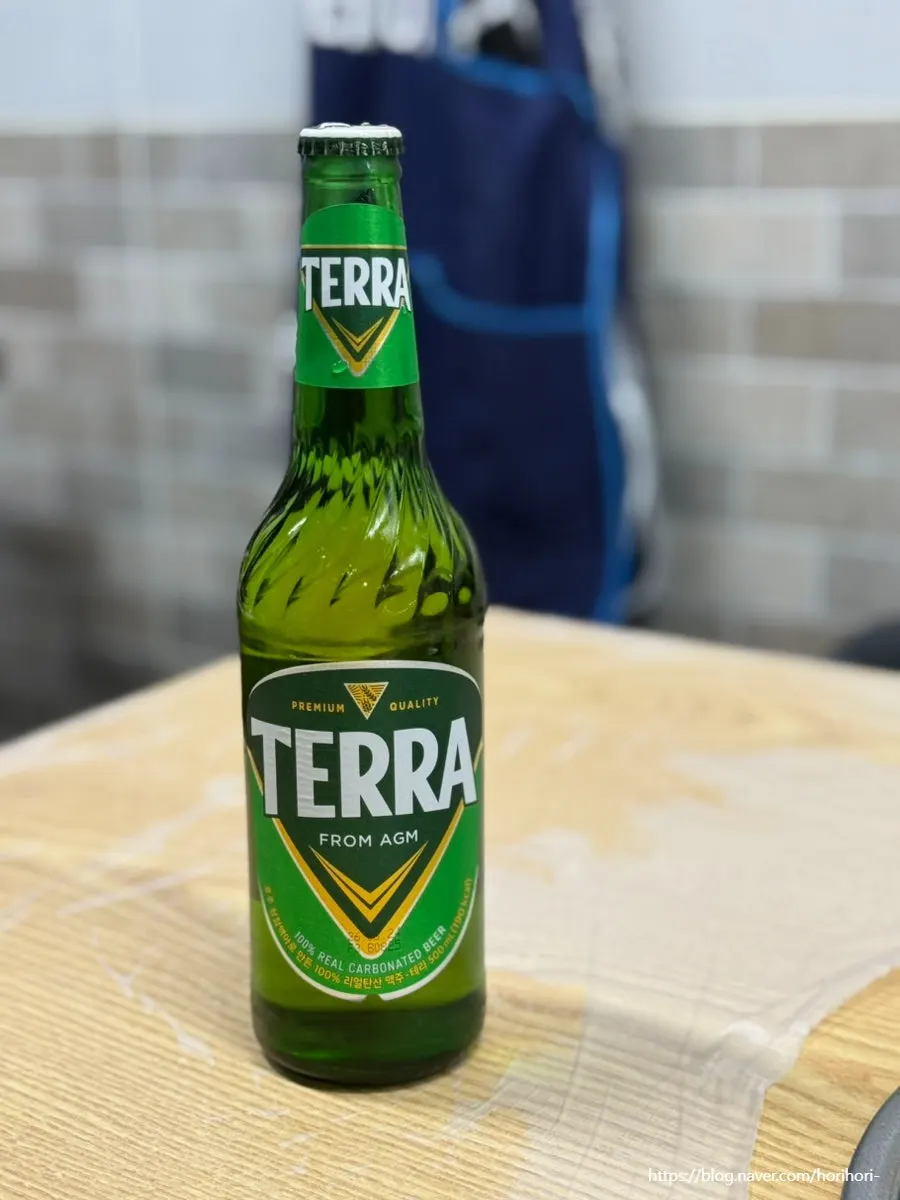 A glass of Terra green-bottle beer