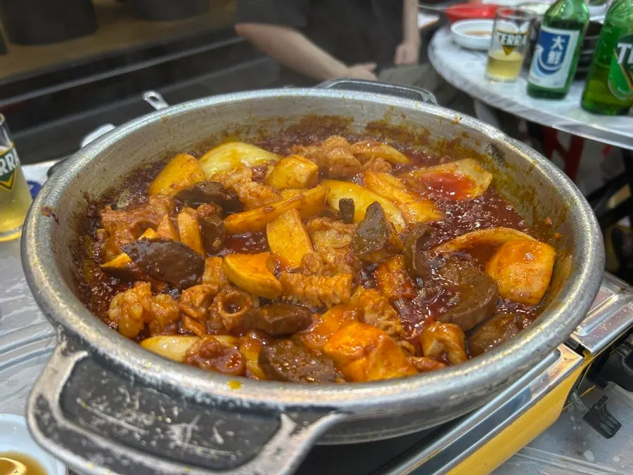 Stone-pan seasoned gopchang developing broth as it cooks