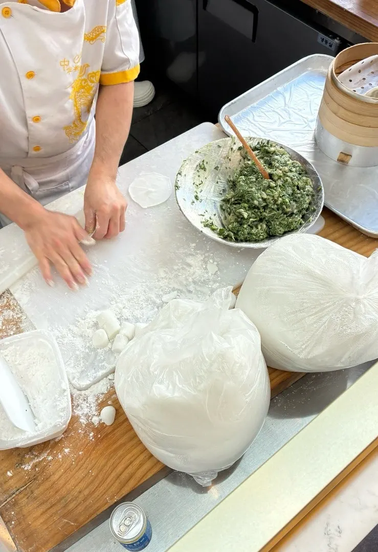 Chefs making dumplings at the store entrance