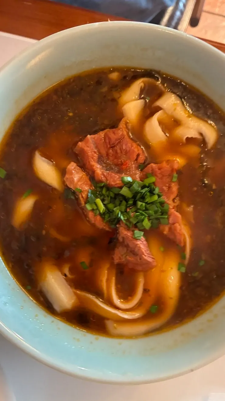 Thick dosakmyeon noodles lifted with chopsticks
