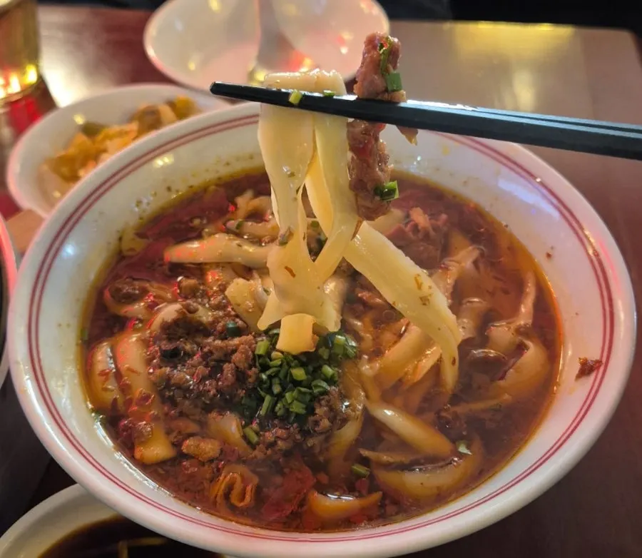 Thick knife-cut noodles lifted with chopsticks