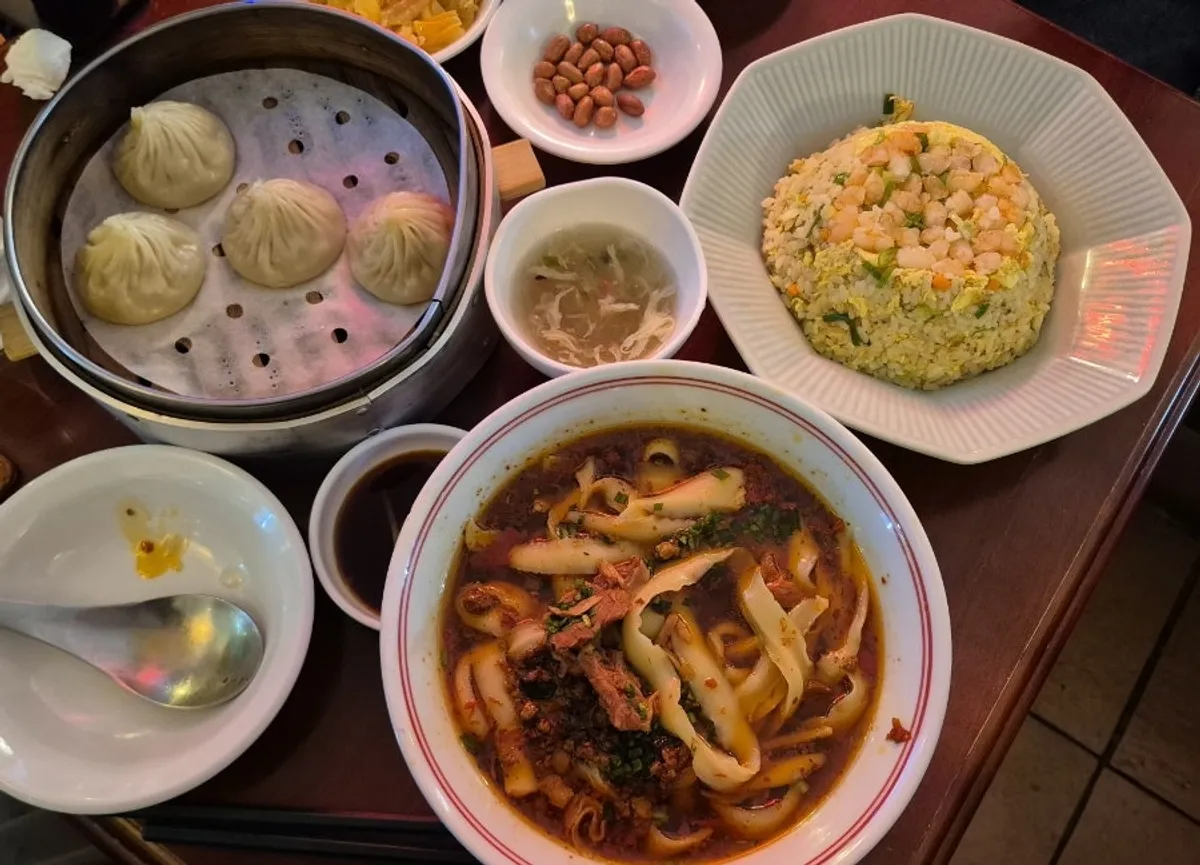 Full spread of beef knife-cut noodles, xiaolongbao, and shrimp fried rice