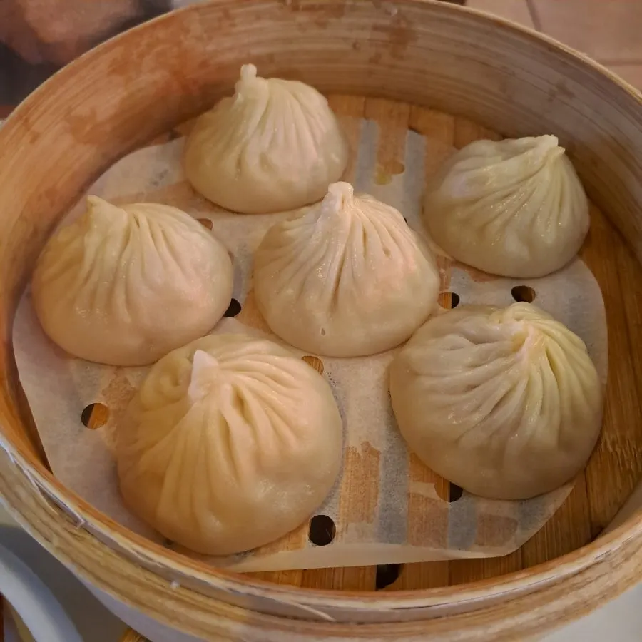 A single xiaolongbao showing its juicy filling