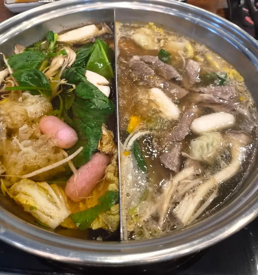 Pot with regular and seafood half-and-half broth