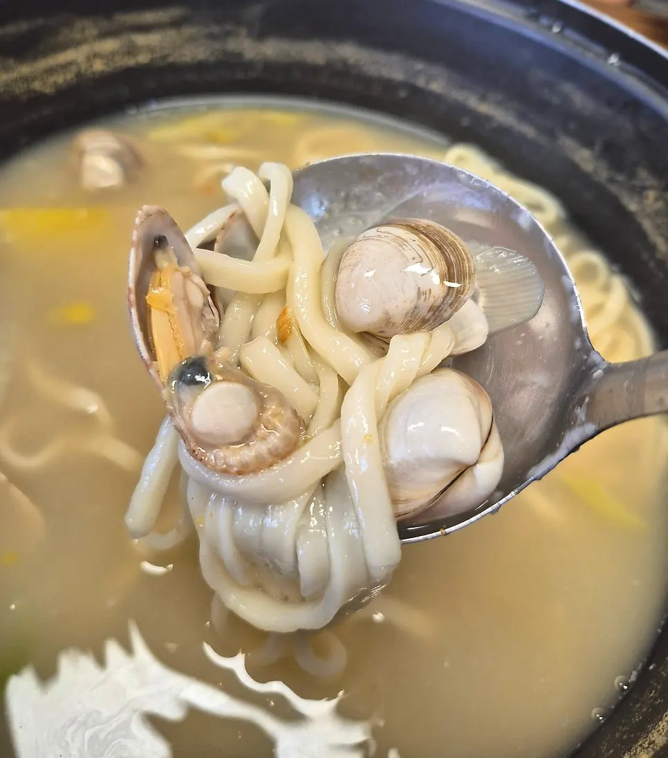 Pot of mixed clam kalguksu simmering