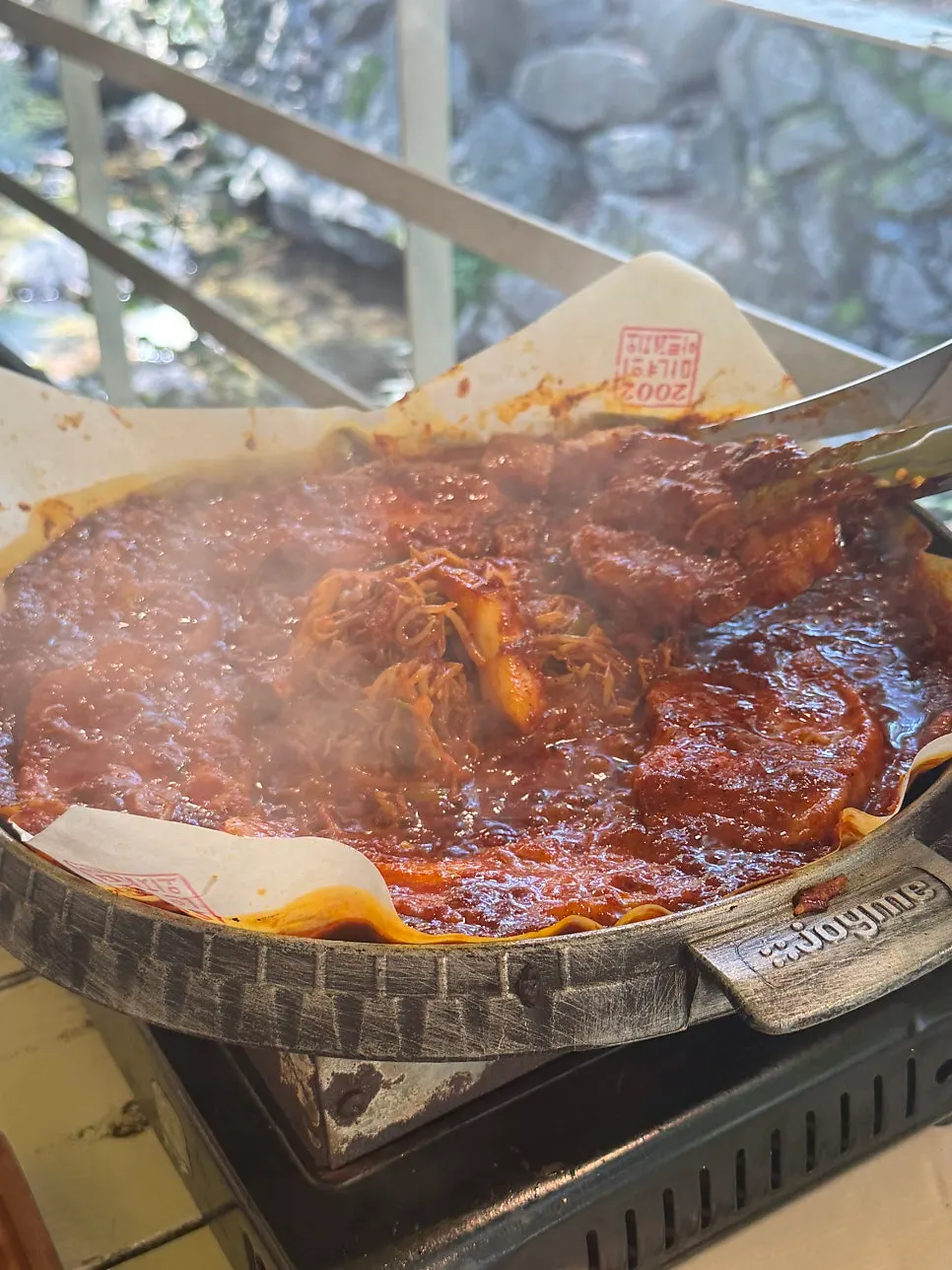 Table spread with three servings of tomato-jang pork belly