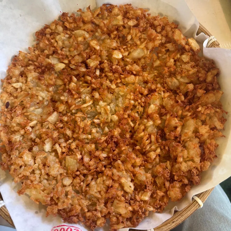 A piece of potato pancake with soy-marinated onions