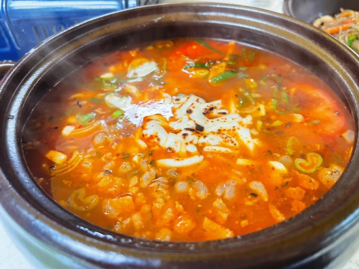 New tomato-jang kalguksu served in an earthenware pot