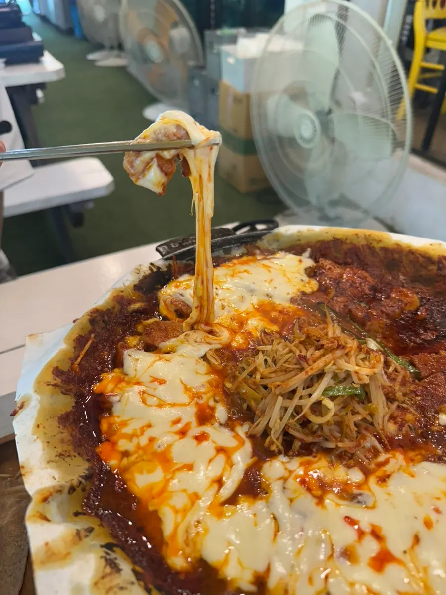 A piece of tomato-sauce pork belly picked up together with cheese