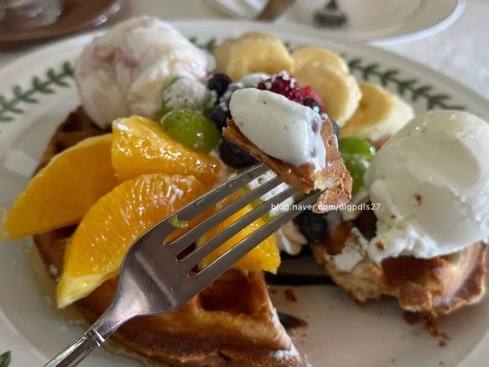 Plate of waffle topped with ice cream and fruit