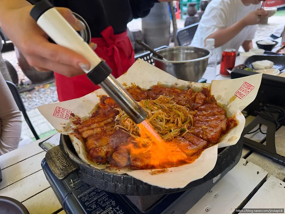 Staff torching cheese on top of the dish