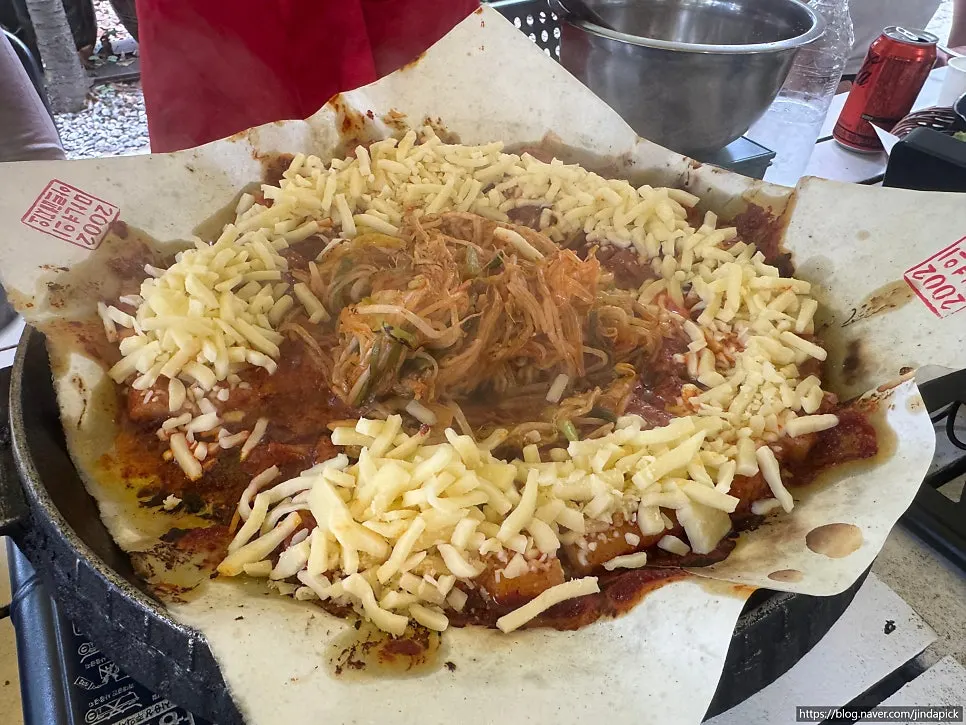 A piece of pork belly topped with melted cheese