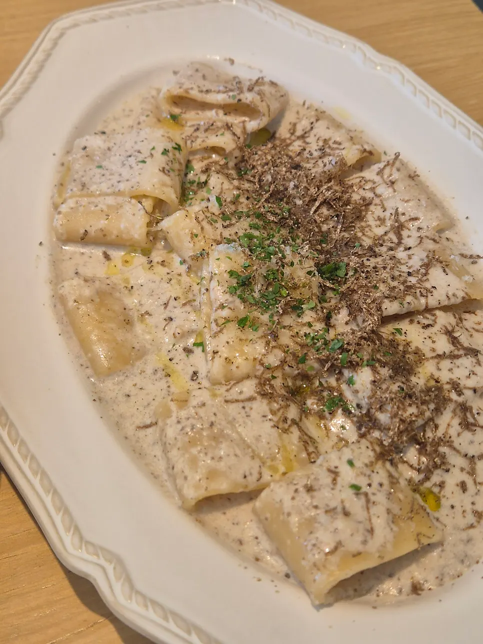 Cream pasta topped with sliced truffle