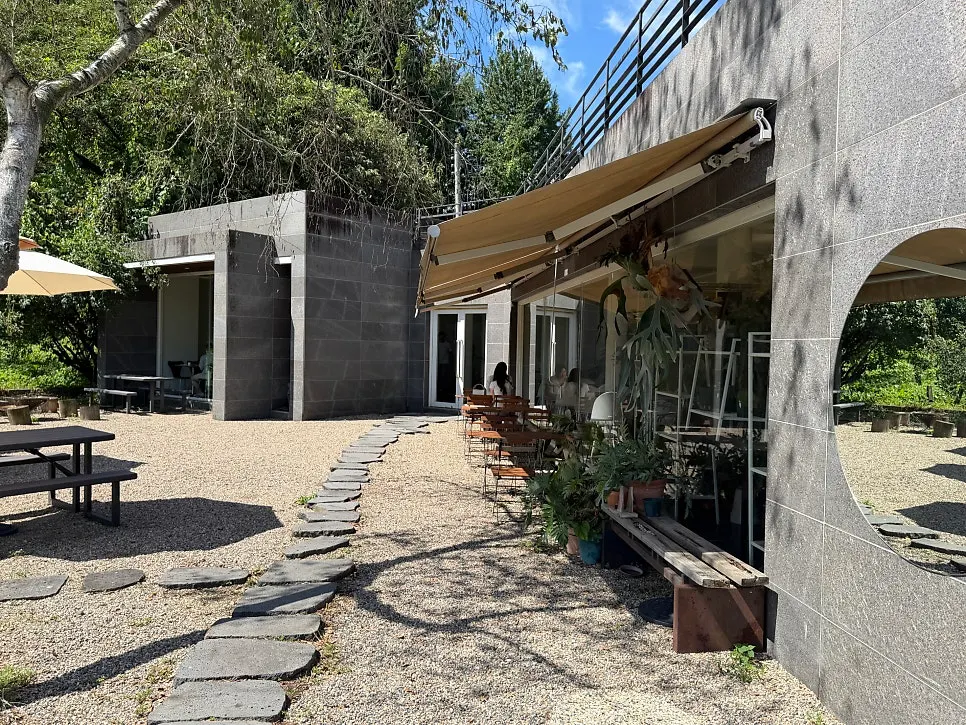 Parasol-covered outdoor tables on the gravel yard